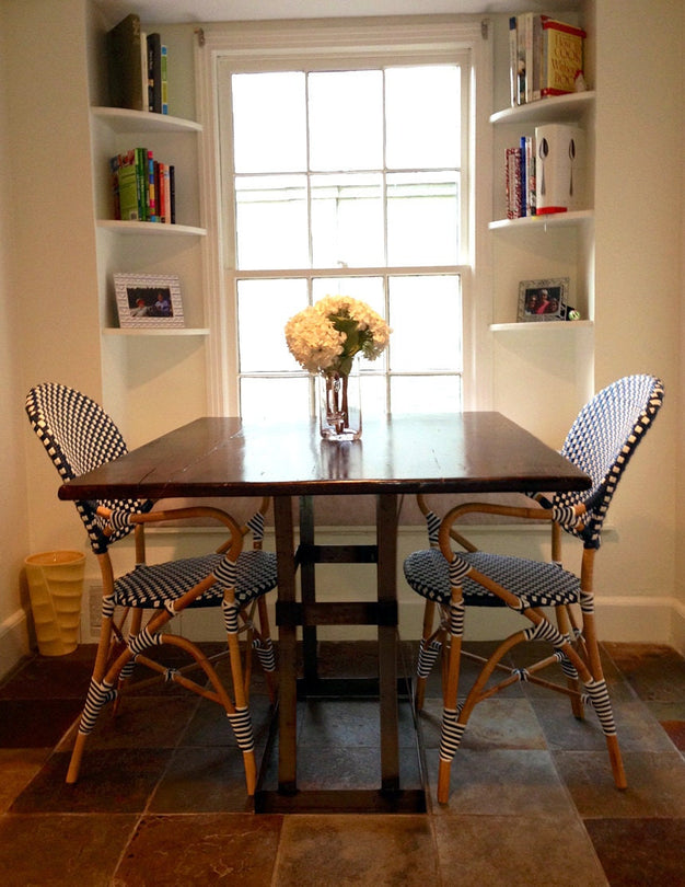 Reclaimed wood dining table in a room with two chairs close to a window