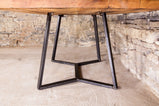 Live edge dining table with big wooden top in a stone room