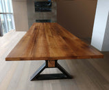Conference table in a meeting room with square shaped wooden top and triangle metal legs