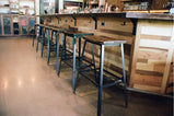 Bar stools with industrial design, wooden top and metal legs in a pub