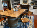 Bar stools in a living room close to big a wooden table with flowers on it